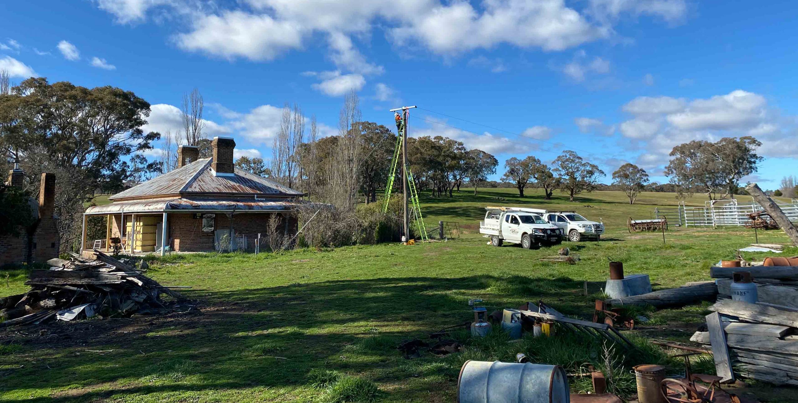 Two vehicles owned by Orange Electrical Works at rural electrical project